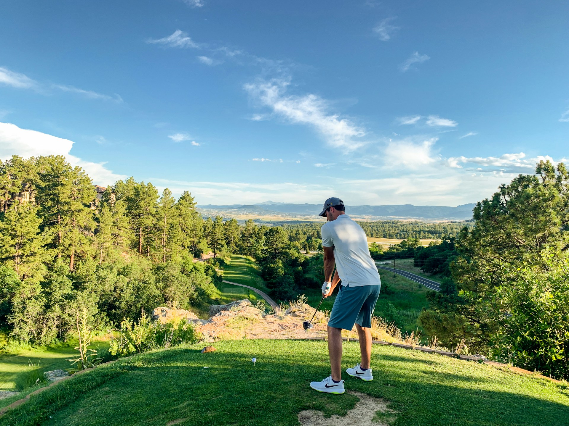 kille som spelar golf med fin utsikt